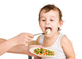 Little boy tasting vegetable salad