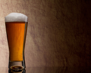 Beer into glass on a old stone