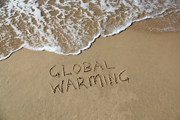 Global warming written in the sand at beach