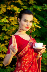 woman in Indian sari with cup of tea