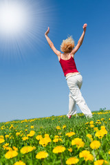 young woman in red outfit having fun on meadow