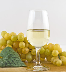 vino bianco in calice con uva