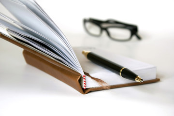 pen notebook and eyeglasses isolated