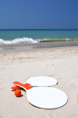 Fototapeta na wymiar Dwie rakiety i piłka na plaży