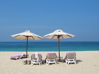 Fototapeta na wymiar Sun umbrellas and chairs on the Bang Tao beach of Phuket island