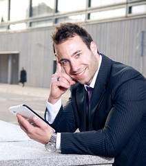 Portrait of happy young businessman holding touchscreen tablet