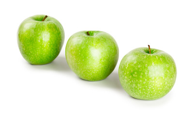 Three ripe and juicy green apples located in a line isolated