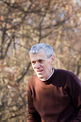 nice elderly white-haired man in a autumn park