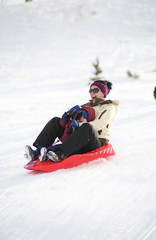 Fototapeta na wymiar family sledding during winter down a hill