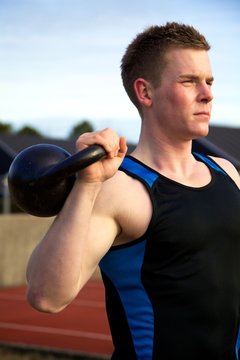 Young Man Doing Kettlebell Exercise Outside