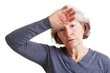 Seniorin hält Hand an die Stirn