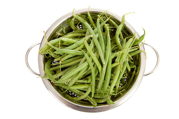 colander with long green beans over white background