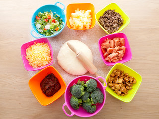 Making pizza: ingredients and pasta dough on wooden cutting boar