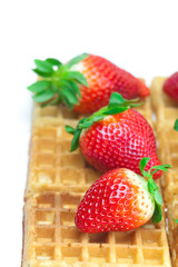 big juicy ripe strawberries and waffles isolated on white