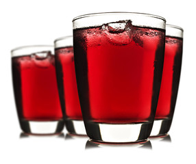 Four glasses of red fruit juice with ice