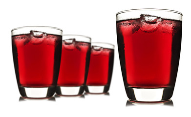Four glasses of red fruit juice with ice