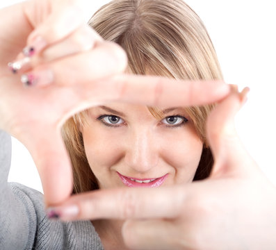 Young attractive woman framing her hands, clear vision, isolated