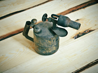 Old blowtorch on a wooden background