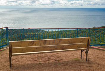 Naklejka na ściany i meble Bench with view at the sea.