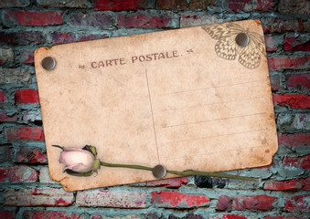 Old postcard on the brick wall