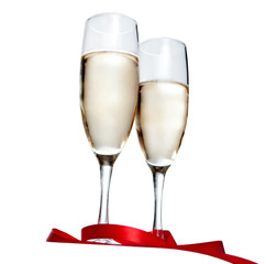 Glasses with Champagne and red ribbon isolated on white