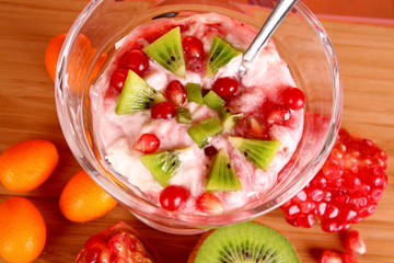 some coctail with fruits in glass with spoon on red background
