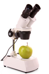 Green apple and microscope isolated on white