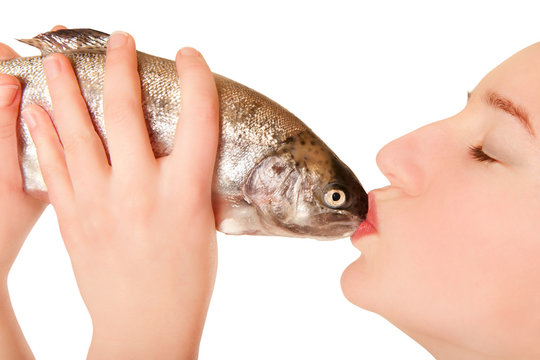 Schöne junge Frau küsst einen Fisch, freigestellt