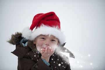 Kleiner Junge pustet Schnee