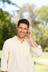 Handsome man phoning in the park