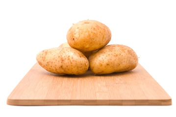 Fresh potatoes with board on a white background