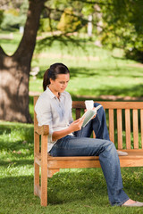 Obraz premium Young woman reading on the bench