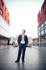 Proud businessman standing in the street looking up