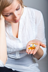 Woman holding pharmaceuticals on neutral bg