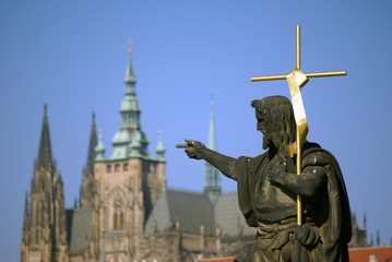 Fototapeta premium Heiligenstatue in Prag mit dem Dom im Hintergrund