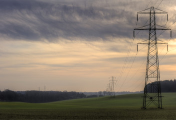 Electricity cable communication towers on sunrise landscape