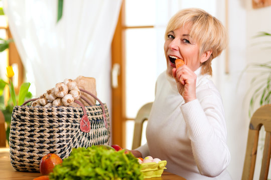 Woman With Groceries Eating Carrot