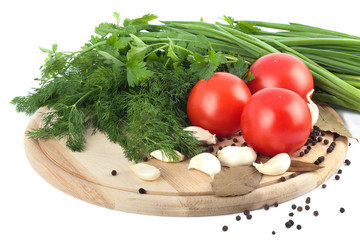 Raw vegetables on cutting board on white background