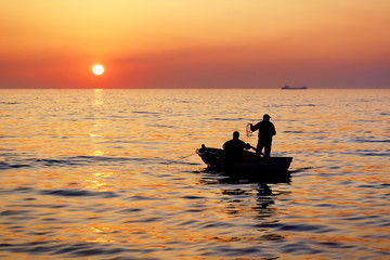 Fototapeta premium Fisherman boat on sunset