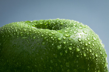 Green apple covered in water droplets