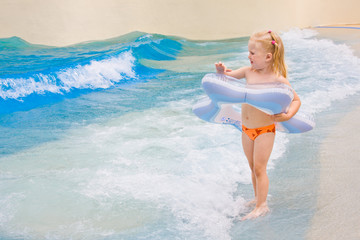 Little girl playing in blue water