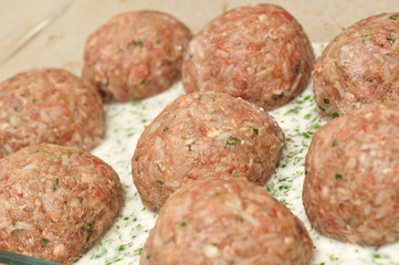 close up of meatballs ready to be cooked in a garlic sauce