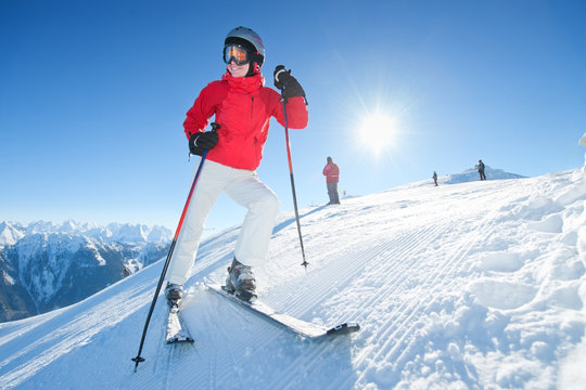 Young woman with ski stand at tom of the hill