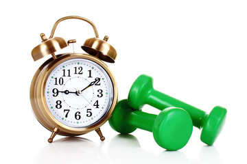 Old alarm-clock and dumbbells isolated on white