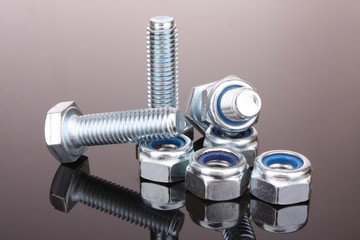 Screw and bolt with reflection on grey background