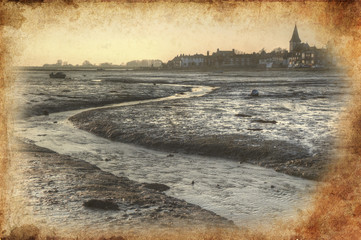 Low tide harbour at sunset with nearby town in distance retro gr