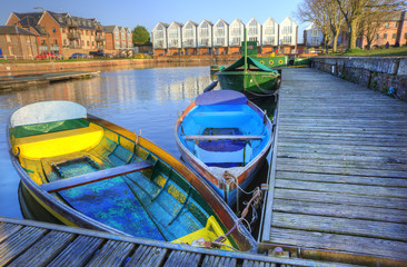 Bright colorful rowing boats in urban canal landscape