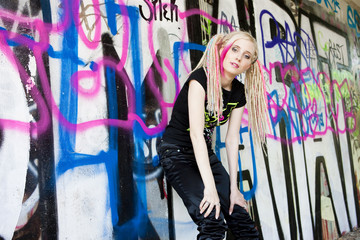 young woman standing at graffitti wall