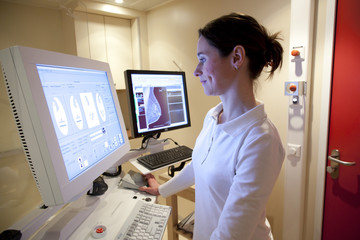Radiology technician performing mammography scan - obrazy, fototapety, plakaty