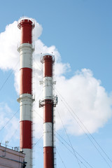 Two striped pipes against sky.